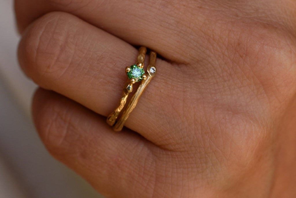 hand wearing the miss twiggy engagement / solitaire ring from gold with green diamond